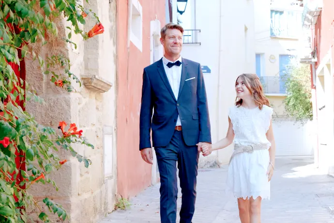 Sébastien partage un moment avec sa fille dans les ruelles d’un petit village pendant leur mariage au Château Sainte-Colombe-de-B