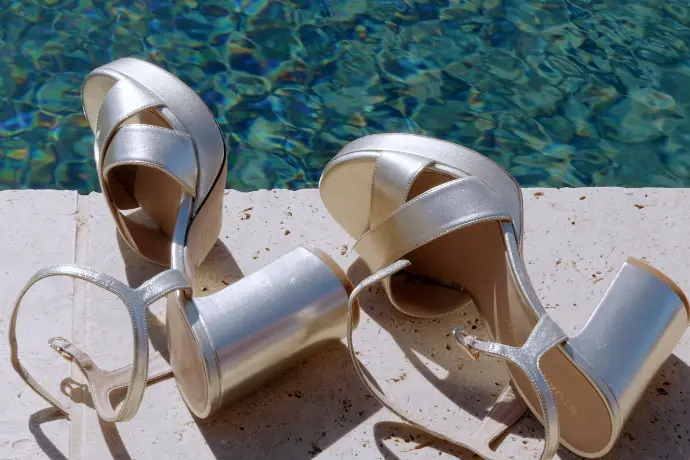 Les chaussures de la mariée photographiées au bord de la piscine du Château Capitoul, un détail élégant du mariage de Valérie et Alan.