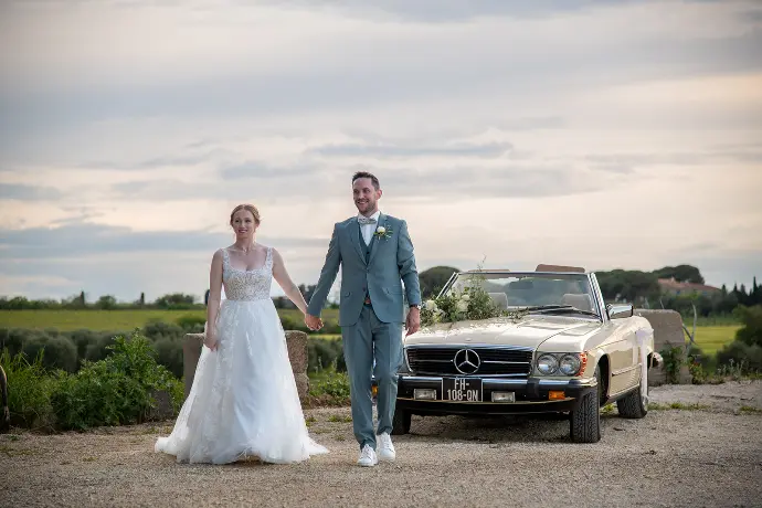 Estelle et Arnaud marchent main dans la main au Domaine des Barrettes à Agde, un moment simple et complice capturé pendant leur mariage.