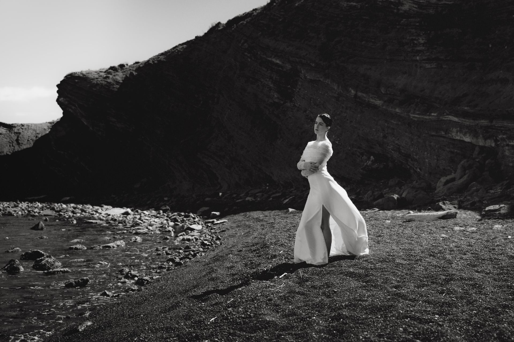 silhouette de mariée sur roche volcanique dans un paysage brut en bord de mer